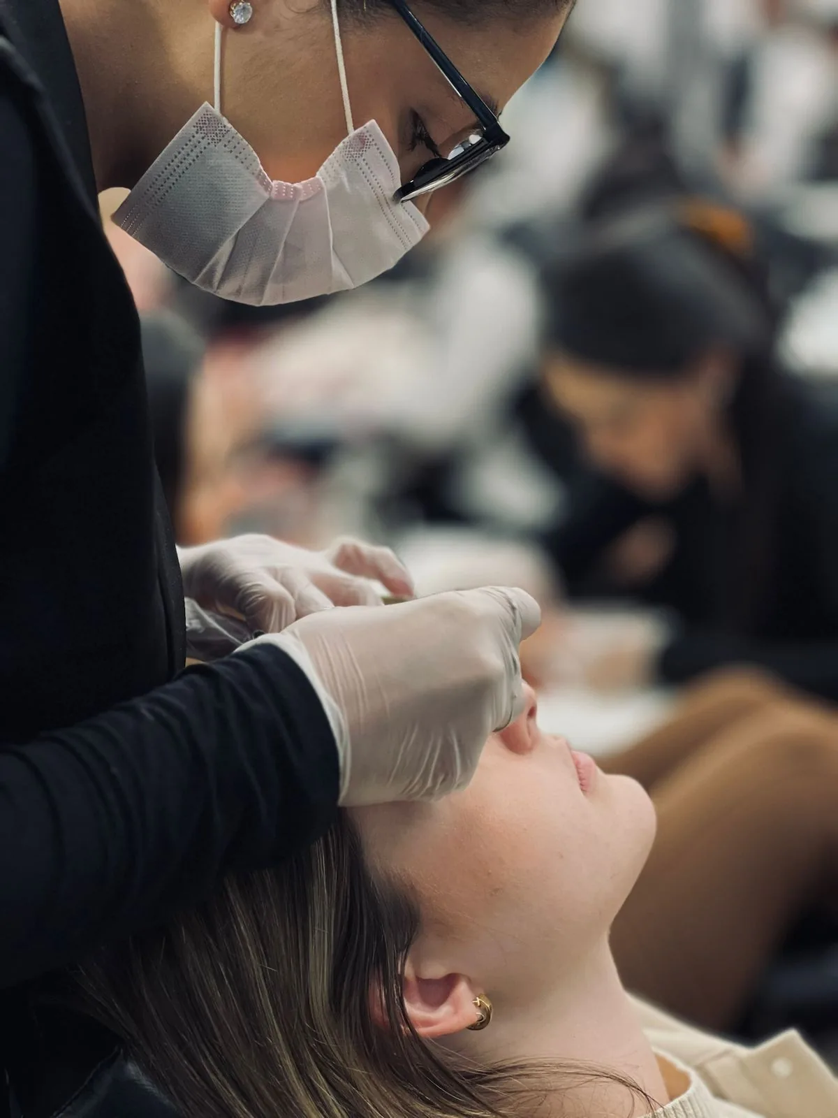 Atendimento de cílios com profissional usando proteção